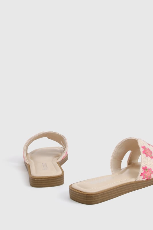 Charming crochet slide sandals featuring a delicate floral pattern
        Comfortable flat design with a heel height between 0-2cm for all-day wear
        Wide single strap across the foot for easy slip-on styling
        Cushioned footbed providing essential comfort for summer adventures
        Durable wooden-effect sole with subtle stacked appearance
    
    These crochet cut-out sandals bring a touch of artisanal charm to your summer wardrobe. The intricate floral crochet detailing adds texture and visual interest to an otherwise simple silhouette, making these slides perfect for the fashion-forward woman who appreciates handcrafted details. Pair with frayed denim shorts and an oversized linen shirt for casual beach days, or style with a flowing maxi dress for garden parties and family gatherings. The flat design ensures comfort whilst strolling through farmers' markets or enjoying afternoon tea with friends. These versatile sandals transition effortlessly from daytime casual to relaxed evening settings, making them an essential addition to your holiday packing list. Their slip-on design offers convenience without compromising on style, embodying the carefree spirit of summer dressing that Boohoo customers adore.