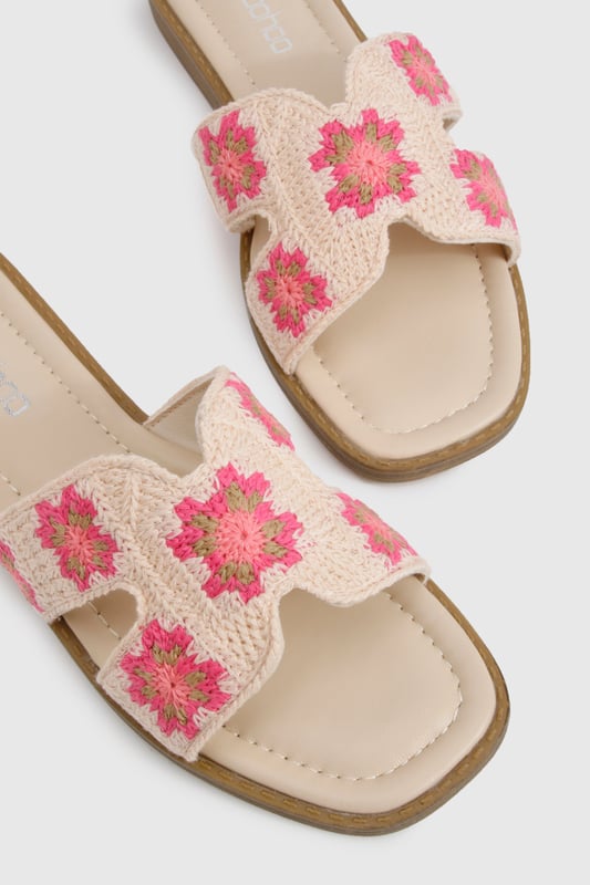 Charming crochet slide sandals featuring a delicate floral pattern
        Comfortable flat design with a heel height between 0-2cm for all-day wear
        Wide single strap across the foot for easy slip-on styling
        Cushioned footbed providing essential comfort for summer adventures
        Durable wooden-effect sole with subtle stacked appearance
    
    These crochet cut-out sandals bring a touch of artisanal charm to your summer wardrobe. The intricate floral crochet detailing adds texture and visual interest to an otherwise simple silhouette, making these slides perfect for the fashion-forward woman who appreciates handcrafted details. Pair with frayed denim shorts and an oversized linen shirt for casual beach days, or style with a flowing maxi dress for garden parties and family gatherings. The flat design ensures comfort whilst strolling through farmers' markets or enjoying afternoon tea with friends. These versatile sandals transition effortlessly from daytime casual to relaxed evening settings, making them an essential addition to your holiday packing list. Their slip-on design offers convenience without compromising on style, embodying the carefree spirit of summer dressing that Boohoo customers adore.