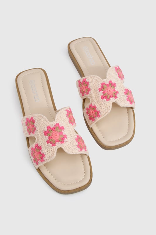 Charming crochet slide sandals featuring a delicate floral pattern
        Comfortable flat design with a heel height between 0-2cm for all-day wear
        Wide single strap across the foot for easy slip-on styling
        Cushioned footbed providing essential comfort for summer adventures
        Durable wooden-effect sole with subtle stacked appearance
    
    These crochet cut-out sandals bring a touch of artisanal charm to your summer wardrobe. The intricate floral crochet detailing adds texture and visual interest to an otherwise simple silhouette, making these slides perfect for the fashion-forward woman who appreciates handcrafted details. Pair with frayed denim shorts and an oversized linen shirt for casual beach days, or style with a flowing maxi dress for garden parties and family gatherings. The flat design ensures comfort whilst strolling through farmers' markets or enjoying afternoon tea with friends. These versatile sandals transition effortlessly from daytime casual to relaxed evening settings, making them an essential addition to your holiday packing list. Their slip-on design offers convenience without compromising on style, embodying the carefree spirit of summer dressing that Boohoo customers adore.
