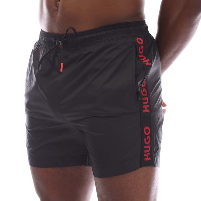 Mens Hugo Fab Logo Tape Swim Shorts in black.- Elasticated waistband.- Side pockets.- Patch pocket.- Trimmed with logo tape on the side seams.- Regular fit.- 100% Polyamide.- Ref: 50500973001