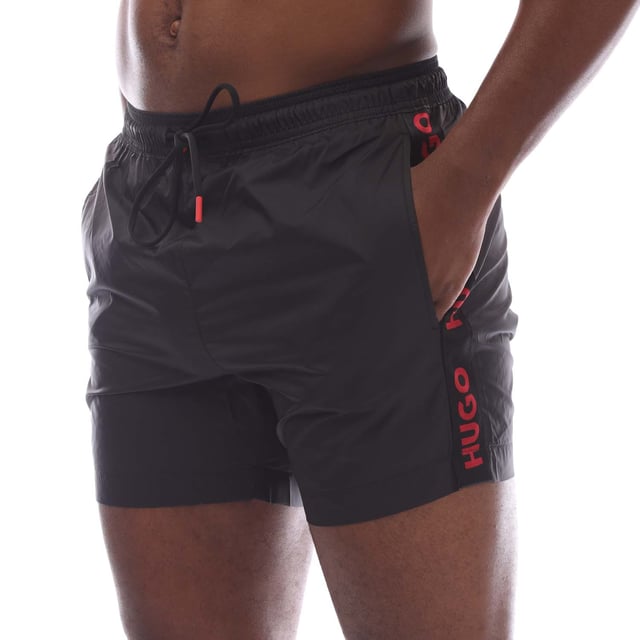 Mens Hugo Fab Logo Tape Swim Shorts in black.- Elasticated waistband.- Side pockets.- Patch pocket.- Trimmed with logo tape on the side seams.- Regular fit.- 100% Polyamide.- Ref: 50500973001