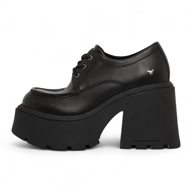 Trek de aandacht met de Windsor Smith Starcrossed platformschoenen - de ultieme combinatie van attitude en lengte. Deze dikke veterschoenen met een strak bovenwerk van zwart leer zijn voorzien van de kenmerkende noppenzool van het merk, die zowel grip als een opvallende stijl biedt. De ronde neus en lichtgewicht TPR-constructie zorgen voor comfort, terwijl de torenhoge hak van 12 cm en het platform van 5,3 cm je maximale lift geven. Afgewerkt met het iconische stierenlogo van Windsor Smith op het bovenwerk, zijn ze ontworpen voor een onverschrokken, modieuze look. Bovenwerk: Leer Voering: Niet-leer Zool: Lichtgewicht TPR (met noppen) Sluiting: Veter Teen: Rond Platform Hoogte: 5,3 cm Hakhoogte: 12 cm Kenmerken: Dikke zool, stierenlogo
