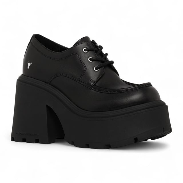 Trek de aandacht met de Windsor Smith Starcrossed platformschoenen - de ultieme combinatie van attitude en lengte. Deze dikke veterschoenen met een strak bovenwerk van zwart leer zijn voorzien van de kenmerkende noppenzool van het merk, die zowel grip als een opvallende stijl biedt. De ronde neus en lichtgewicht TPR-constructie zorgen voor comfort, terwijl de torenhoge hak van 12 cm en het platform van 5,3 cm je maximale lift geven. Afgewerkt met het iconische stierenlogo van Windsor Smith op het bovenwerk, zijn ze ontworpen voor een onverschrokken, modieuze look. Bovenwerk: Leer Voering: Niet-leer Zool: Lichtgewicht TPR (met noppen) Sluiting: Veter Teen: Rond Platform Hoogte: 5,3 cm Hakhoogte: 12 cm Kenmerken: Dikke zool, stierenlogo