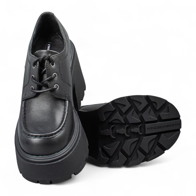 Trek de aandacht met de Windsor Smith Starcrossed platformschoenen - de ultieme combinatie van attitude en lengte. Deze dikke veterschoenen met een strak bovenwerk van zwart leer zijn voorzien van de kenmerkende noppenzool van het merk, die zowel grip als een opvallende stijl biedt. De ronde neus en lichtgewicht TPR-constructie zorgen voor comfort, terwijl de torenhoge hak van 12 cm en het platform van 5,3 cm je maximale lift geven. Afgewerkt met het iconische stierenlogo van Windsor Smith op het bovenwerk, zijn ze ontworpen voor een onverschrokken, modieuze look. Bovenwerk: Leer Voering: Niet-leer Zool: Lichtgewicht TPR (met noppen) Sluiting: Veter Teen: Rond Platform Hoogte: 5,3 cm Hakhoogte: 12 cm Kenmerken: Dikke zool, stierenlogo