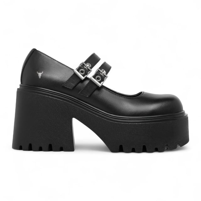 Step into bold style with the Windsor Smith Lessons platform shoes — a modern twist on the classic Mary-Jane. Crafted with a smooth black leather upper, these chunky platforms feature twin adjustable straps with silver hardware, eyelet detailing, and Windsor Smith’s signature bull symbol on the side. Designed for statement-makers, they boast a cleated, lightweight PU sole, a towering 9 cm heel, and a 4.6 cm platform for comfort and impact. With a rounded toe and edgy detailing, they're perfect for elevating any outfit.

Upper: Premium Leather
Lining: Non-Leather
Sole: Lightweight PU
Closure: Twin adjustable straps with silver eyelets
Toe: Rounded
Platform Height: 4.6 cm
Heel Height: 9 cm
Details: Cleated sole, silver hardware, bull logo