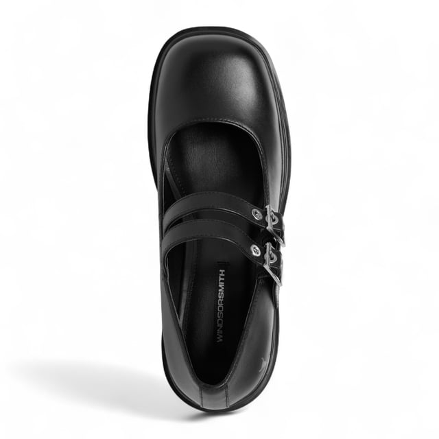 Step into bold style with the Windsor Smith Lessons platform shoes — a modern twist on the classic Mary-Jane. Crafted with a smooth black leather upper, these chunky platforms feature twin adjustable straps with silver hardware, eyelet detailing, and Windsor Smith’s signature bull symbol on the side. Designed for statement-makers, they boast a cleated, lightweight PU sole, a towering 9 cm heel, and a 4.6 cm platform for comfort and impact. With a rounded toe and edgy detailing, they're perfect for elevating any outfit.

Upper: Premium Leather
Lining: Non-Leather
Sole: Lightweight PU
Closure: Twin adjustable straps with silver eyelets
Toe: Rounded
Platform Height: 4.6 cm
Heel Height: 9 cm
Details: Cleated sole, silver hardware, bull logo