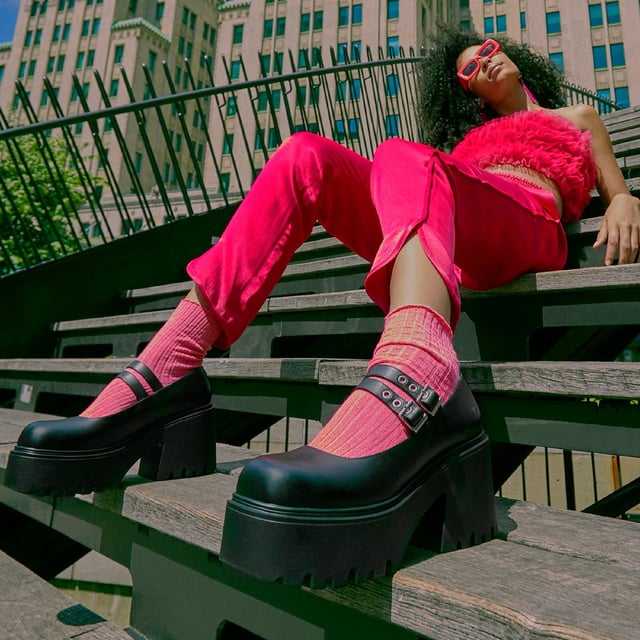 Step into bold style with the Windsor Smith Lessons platform shoes — a modern twist on the classic Mary-Jane. Crafted with a smooth black leather upper, these chunky platforms feature twin adjustable straps with silver hardware, eyelet detailing, and Windsor Smith’s signature bull symbol on the side. Designed for statement-makers, they boast a cleated, lightweight PU sole, a towering 9 cm heel, and a 4.6 cm platform for comfort and impact. With a rounded toe and edgy detailing, they're perfect for elevating any outfit.

Upper: Premium Leather
Lining: Non-Leather
Sole: Lightweight PU
Closure: Twin adjustable straps with silver eyelets
Toe: Rounded
Platform Height: 4.6 cm
Heel Height: 9 cm
Details: Cleated sole, silver hardware, bull logo