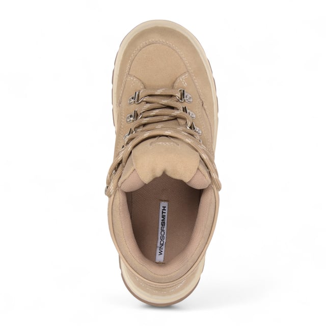 Meet the Windsor Smith Ultimatum - Women’s platform sneakers redefined with a rugged twist. Crafted with a soft sand suede upper and contrast stitching, these chunky sneakers feature a two-tone TPR platform sole that combines street style with hiking influence. Metal hook-and-eye details and bull-logo silver D-rings elevate the design, while the twin-colored laces, padded tongue, and collar offer added comfort. With a 63 mm heel and a 46 mm forepart platform, these cross-hiker sneakers deliver elevated style without compromising stability.

Upper: Sand Suede
Lining: Sports Fabric
Sole: Two-tone Chunky TPR
Closure: Twin-colored lace with metal hook & eye + D-rings
Heel Height: 63 mm
Platform Forepart Height: 46 mm
Design: Cross between hiker boot and sneaker
Details: Padded tongue and collar, contrast stitching, molded footbed