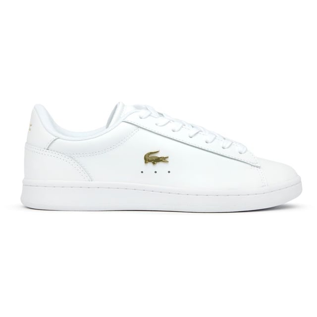 The Lacoste Carnaby Set brings classic court style to your casual collection. These elegant white leather trainers showcase subtle metallic accents that catch the light as you move. With Lacoste's signature branding tastefully placed on the tongue, heel, and quarter, these shoes offer understated luxury. The sturdy rubber cup sole provides reliable traction and durability for everyday wear. Perfect for pairing with anything from tailored trousers to summer dresses.
