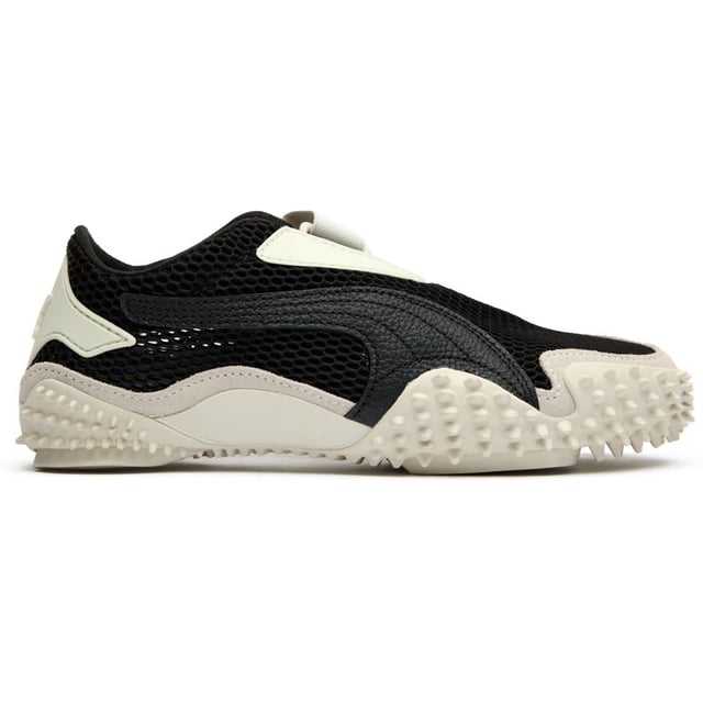 Der Puma Mostro in elegantem Schwarz verwandelt lässiges Schuhwerk mit seinem grenzüberschreitenden Design. Diese hybride Kreation vereint Komfort und unkonventionelle Ästhetik und präsentiert ein markantes, skulpturales Profil, das Aufmerksamkeit erregt. Das strapazierfähige Obermaterial aus Nylon ruht auf einer avantgardistischen Gummisohle mit Spitzen, die unerwarteten Halt bietet, während sie eine schlanke, flache Silhouette beibehält. Perfekt für Trendsetter, die Pumas Erbe innovativer Sportbekleidung mit einem mutigen, zeitgenössischen Twist schätzen.