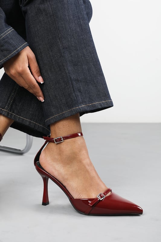 Wheres That From Womens 'Katherine' Strappy Pointed Toe High Heels Make a bold entrance with these Katherine Strappy Pointed Toe High Heels, crafted for standout sophistication. Featuring a pointed toe, slim stiletto heel, and delicate buckle straps, they bring timeless elegance with a modern twist. The glossy finish adds a luxurious edge, perfect for evening events, date nights, or dressing up denim. Key Features: • Material: High-shine patent faux leather upper • Design: Pointed toe with dual buckle strap and stiletto heel • Closure: Adjustable ankle and front buckle straps