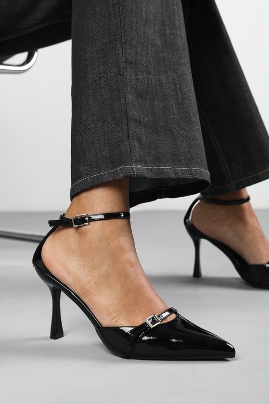Wheres That From Womens 'Katherine' Strappy Pointed Toe High Heels Make a bold entrance with these Katherine Strappy Pointed Toe High Heels, crafted for standout sophistication. Featuring a pointed toe, slim stiletto heel, and delicate buckle straps, they bring timeless elegance with a modern twist. The glossy finish adds a luxurious edge, perfect for evening events, date nights, or dressing up denim. Key Features: • Material: High-shine patent faux leather upper • Design: Pointed toe with dual buckle strap and stiletto heel • Closure: Adjustable ankle and front buckle straps