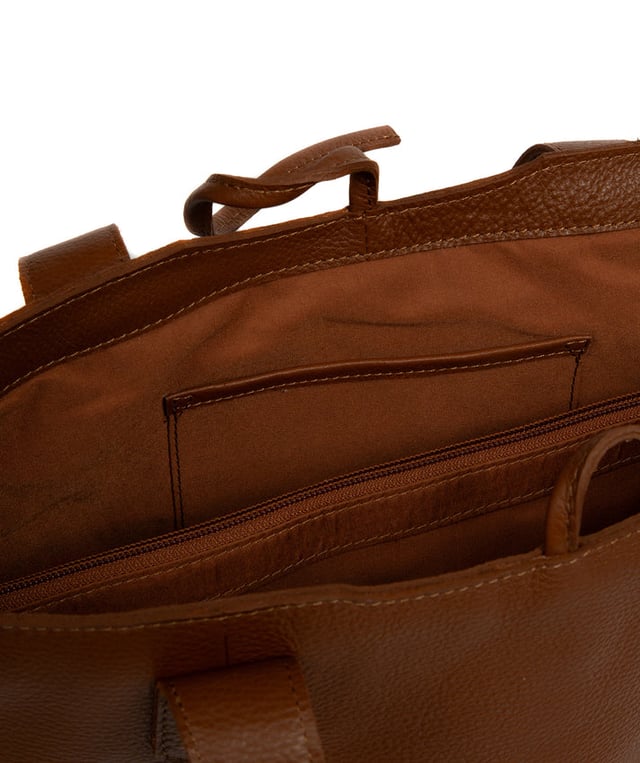 Handcrafted from natural leather with a soft to the touch pebble grain finish, the 'Carolina' tote bag from NiNa Amora is a must-have accessory. A unique tie top secures the central lined compartment which includes a zipped compartment which divides the design; perfect for maintaining an organised bag. Additional storage space is provided by a slip and zipped pocket on the interior, ideal for your phone, keys and any other essentials while out and about. Adorned with dual leather handles with a drop length of 25cm for a comfortable and versatile carrying options. Silver metal fittings and zips give this design a elegant look which is complemented the NiNa Amora X logo is silver foil embossed on the front and hanging charm for a luxurious finishing touch.