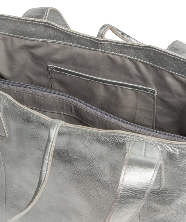 Handcrafted from natural leather with a soft to the touch pebble grain finish, the 'Carolina' tote bag from NiNa Amora is a must-have accessory. A unique tie top secures the central lined compartment which includes a zipped compartment which divides the design; perfect for maintaining an organised bag. Additional storage space is provided by a slip and zipped pocket on the interior, ideal for your phone, keys and any other essentials while out and about. Adorned with dual leather handles with a drop length of 25cm for a comfortable and versatile carrying options. Silver metal fittings and zips give this design a elegant look which is complemented the NiNa Amora X logo is silver foil embossed on the front and hanging charm for a luxurious finishing touch.
