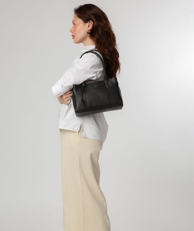 The 'Beatriz' handbag from NiNa Amora is crafted from natural leather with a soft to the touch pebble grain finish. This classic design is elevated thanks to the unique trio of main compartments. This comes in the form of a zipped central section with two magnetic press stud fastened slip pockets on either side; perfect for maintaining an organised accessory. Additional storage space is provided by slip pockets on the interior and exterior alongside a zipped pocket which lines the interior. Dual rounded leather handles adorn the bag with a drop length of 20cm. Silver coloured metal fittings and zips give this design a elegant look which pops against the leather exterior and complemented the NiNa Amora X logo which is silver foil embossed on the front and hanging charm for a luxurious finishing touch.