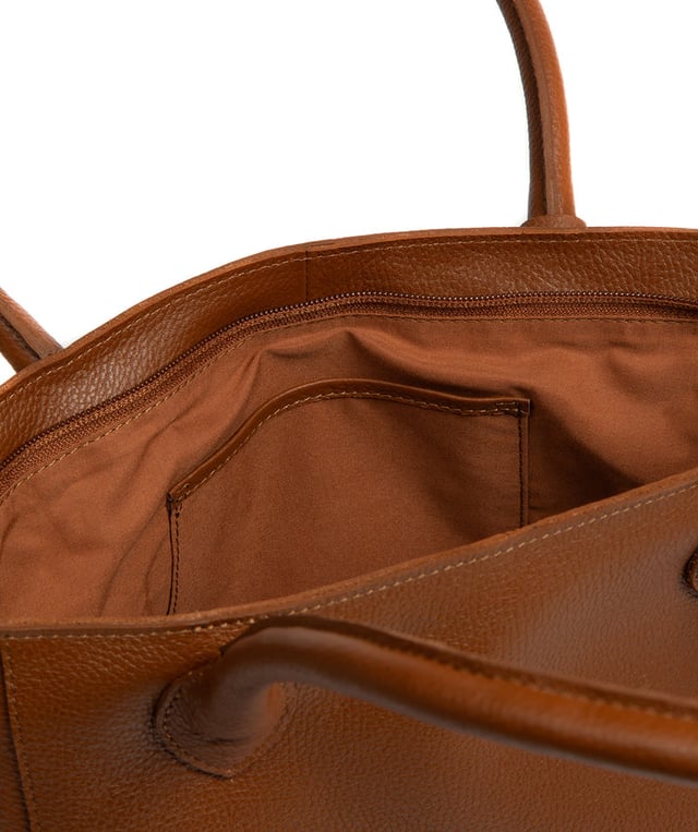 As part of the NiNa Amora brand, the 'Margarida' tote bag is inspired by our designer's daughter and all about elevating classic designs with high quality leather. A concealed zip-over top secures the spacious main lined compartment which opens to reveal additional storage space in the form of a slip and zipped pocket; ideal for your phone, keys and any other essentials. The classic angular sides of the tote are updated with this sophisticated design and adorned with slim leather handles with a drop length of 20cm. This bag is finished with sophisticated silver metal fittings and zips which are complemented by the NiNa Amora X logo embossed in silver on the front and on the hanging charm. Effortlessly chic.