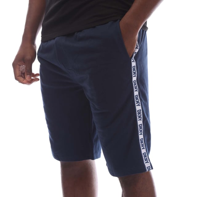 Mens DKNY Sea Dogs Lounge Shorts in navy.- Elasticated waistband with drawstring fastening.- Two handy side pockets.- DKNY branding down the leg.- Spun in soft jersey fabric.- 100% Cotton.- Ref: N56804DKYNV
