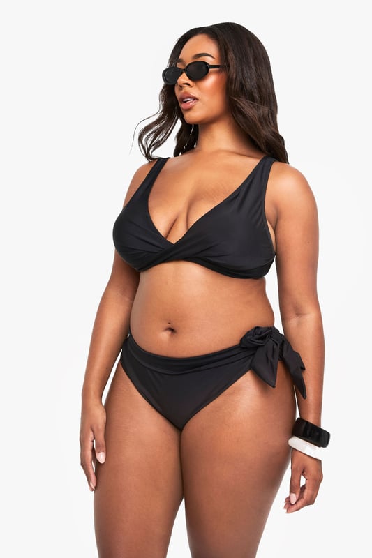 Stylish lace-up detail on the sides for an adjustable fit
        Mid-rise design offering comfortable coverage
        Side tie feature that can be styled in multiple ways
        Smooth fabric with excellent stretch for all-day comfort
        Designed specifically for curvy figures in our inclusive plus size range
    
    Make waves this season with our plus size lace-up bikini bottoms from Boohoo. These versatile bottoms feature an eye-catching side tie detail that allows you to customise your look and adjust for the perfect fit. The mid-rise design offers just the right amount of coverage whilst maintaining a fashion-forward silhouette. Pair with the matching bikini top as shown for a coordinated beach look, or mix with other tops in your collection for a personalised style statement. Perfect for your next holiday, lounging by the pool or soaking up the sun at the beach. The stretchy fabric moves with your body for lasting comfort throughout the day, whilst the classic design ensures these bottoms will remain a staple in your swimwear collection for seasons to come.