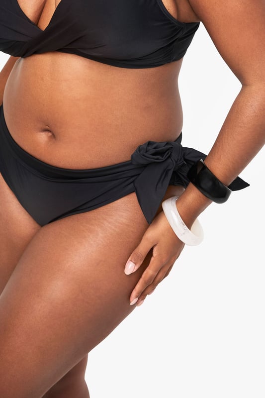 Stylish lace-up detail on the sides for an adjustable fit
        Mid-rise design offering comfortable coverage
        Side tie feature that can be styled in multiple ways
        Smooth fabric with excellent stretch for all-day comfort
        Designed specifically for curvy figures in our inclusive plus size range
    
    Make waves this season with our plus size lace-up bikini bottoms from Boohoo. These versatile bottoms feature an eye-catching side tie detail that allows you to customise your look and adjust for the perfect fit. The mid-rise design offers just the right amount of coverage whilst maintaining a fashion-forward silhouette. Pair with the matching bikini top as shown for a coordinated beach look, or mix with other tops in your collection for a personalised style statement. Perfect for your next holiday, lounging by the pool or soaking up the sun at the beach. The stretchy fabric moves with your body for lasting comfort throughout the day, whilst the classic design ensures these bottoms will remain a staple in your swimwear collection for seasons to come.