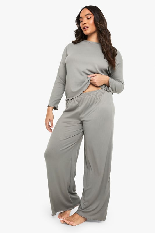 Ribbed texture throughout for added comfort and visual interest
        Relaxed long-sleeve top with distinctive ruffle-trimmed hem
        Wide-leg trousers with matching ruffle detail at the hem
        Soft, stretchy fabric ensures unrestricted movement
        Inclusive plus-size design that flatters your natural silhouette
    
    Embrace laid-back luxury with this Boohoo ribbed loungewear set, thoughtfully designed for those moments when comfort is non-negotiable but style remains essential. The top features a relaxed fit with a playful ruffled hem that adds a feminine touch to casual wear, while the coordinating wide-leg trousers create a balanced silhouette that moves beautifully with you. Perfect for weekend brunches at home, film nights with friends, or simply unwinding after a busy day. Layer with a chunky cardigan and fluffy slippers during colder months, or wear the top with your favourite denim for a quick dash to the shops. This versatile set transitions effortlessly between lounging and casual outings, making it an indispensable addition to your off-duty wardrobe.