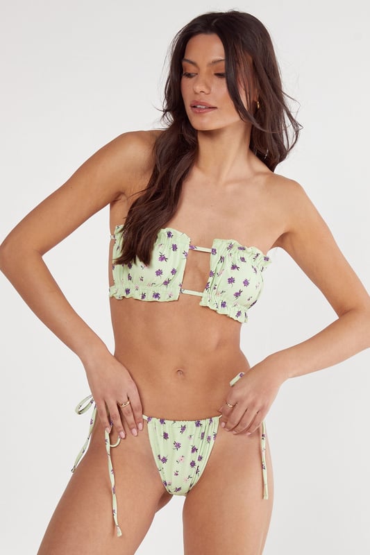Bandeau bikini top with eye-catching centre cut-out detail and decorative metal bar
        Delicate ruched fabric detailing across the bust for a flattering silhouette
        Tie-side bikini bottoms with adjustable fit for personalised comfort
        Ditsy floral pattern throughout the set for a feminine, playful aesthetic
        Strapless design perfect for minimising tan lines whilst lounging poolside
    
    Make a statement by the water with this striking Nasty Gal bandeau bikini set. The distinctive centre cut-out with metal bar detail creates a contemporary twist on a classic silhouette, whilst the ruched fabric adds texture and dimension. The tie-side bottoms allow for a customised fit that moves with you whether you're taking a refreshing dip or relaxing on a sun lounger. Style with oversized sunglasses and a lightweight kimono for trips to the beach bar, or pair with a flowing maxi skirt for seaside strolls. This versatile set transitions effortlessly from daytime sunbathing to sunset cocktails, making it an essential addition to your holiday wardrobe. Perfect for those who want to combine comfort with head-turning style on their next beachside getaway.