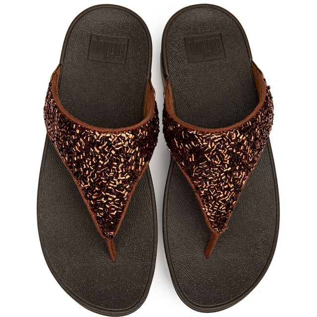 Sandalias Fitflop Lulu Shimmerfoil Las Fitflop Lulu Shimmerfoil aportan un glamour sin esfuerzo a tu paso diario con su llamativo acabado metálico y sutiles detalles de brillo. Construidas sobre la suela micro wobbleboard característica de Fitflop, estas chanclas ofrecen una comodidad excepcional mientras que el tacón de 4 cm añade justo la cantidad adecuada de elevación. La parte superior sintética garantiza durabilidad, mientras que la suela de goma proporciona un agarre fiable para el uso durante todo el día.