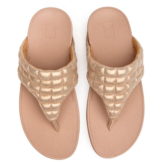 Fitflop Lulu Padded Shimmy Sandals Shimmer your way through summer in these luxuriously padded flip flops that prove comfort and glamour can coexist beautifully. The soft pink synthetic upper cradles your feet while the innovative micro wobbleboard sole works to tone and engage your muscles with every step. At 4cm, these elevated sandals add just the right amount of lift without sacrificing the legendary Fitflop comfort that keeps you walking in blissful ease all day long.