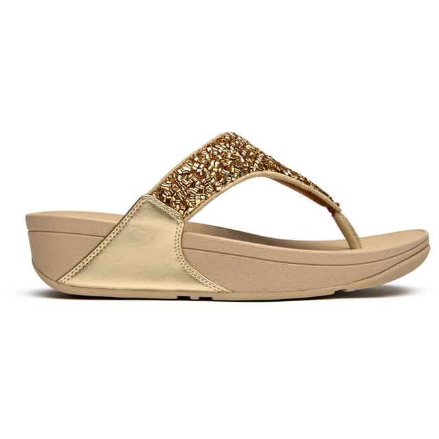 The Fitflop Lulu Shimmerfoil brings glamour to your everyday stride with its eye-catching metallic finish that catches the light beautifully. These sophisticated flip flops feature Fitflop's signature micro wobbleboard sole technology, delivering exceptional comfort and support with every step. The 4cm heel adds a subtle lift while the shimmering synthetic upper creates an effortlessly chic look that transitions seamlessly from poolside to pavement.