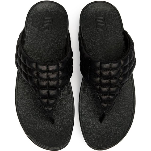 Sandalias Fitflop Lulu Shimmy Con Almohadilla El Fitflop Lulu Padded Shimmy transforma la simple chancleta en una experiencia de bienestar para tus pies. Con su parte superior acolchada y suave y su innovadora suela de micro wobbleboard, cada paso activa tus músculos mientras proporciona una comodidad similar a la de una nube. La elegante construcción sintética negra se combina sin esfuerzo con cualquier look veraniego, mientras que el tacón de 4 cm añade el levantamiento justo para alargar tu silueta. ¿Quién sabía que sentirse bien podría verse tan bien?