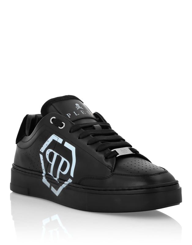Estas zapatillas de caña baja combinan a la perfección la modernidad y la artesanía de lujo, con un emblemático emblema hexagonal que transmite un estilo atrevido y contemporáneo.   Confeccionadas en piel de ternero de primera calidad para un acabado refinado y flexible.   Adornado con un llamativo emblema hexagonal que añade un toque distintivo.   Los detalles de inserción metálica realzan el atractivo moderno de la zapatilla.   Forradas en piel lisa para ofrecer comodidad durante todo el día y un tacto premium.   Perfectas para elevar los looks informales con una silueta impactante.