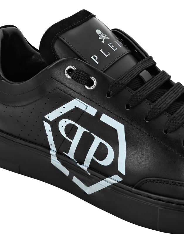 Estas zapatillas de caña baja combinan a la perfección la modernidad y la artesanía de lujo, con un emblemático emblema hexagonal que transmite un estilo atrevido y contemporáneo.   Confeccionadas en piel de ternero de primera calidad para un acabado refinado y flexible.   Adornado con un llamativo emblema hexagonal que añade un toque distintivo.   Los detalles de inserción metálica realzan el atractivo moderno de la zapatilla.   Forradas en piel lisa para ofrecer comodidad durante todo el día y un tacto premium.   Perfectas para elevar los looks informales con una silueta impactante.