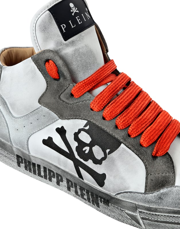Diese High-Top-Sneaker kanalisieren Retro-Coolness mit einem modernen Twist und vereinen mühelos kühnes Design mit luxuriöser Handwerkskunst für auffälligen Streetstyle.   Gefertigt aus einer Mischung aus hochwertigem Rindspaltleder und Kalbsleder für ein raffiniertes, strukturiertes Finish.   Das charakteristische Totenkopf-Detail unterstreicht den kantigen, unverwechselbaren Look der Sneaker.   Weiches Lederfutter sorgt für überlegenen Komfort und Atmungsaktivität.   High-Top-Silhouette fügt eine dynamische Aussage zu jedem Outfit hinzu.   Perfekt für die Aufwertung von Streetwear-inspirierten Looks mit einem Hauch von Luxus Kante.