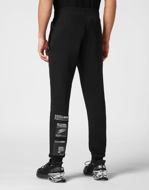 These joggers are the perfect match to achieve your goals. Comfort and performance add up to the style of Plein Sport.   Cotton fleece   Rubberized Tiger patch sewn on the left leg   Patches with lettering sewn on the back of left leg   Elasticated waistband    Two slit pockets   Loose fit for greater comfort   Rib knit bottom cuffs