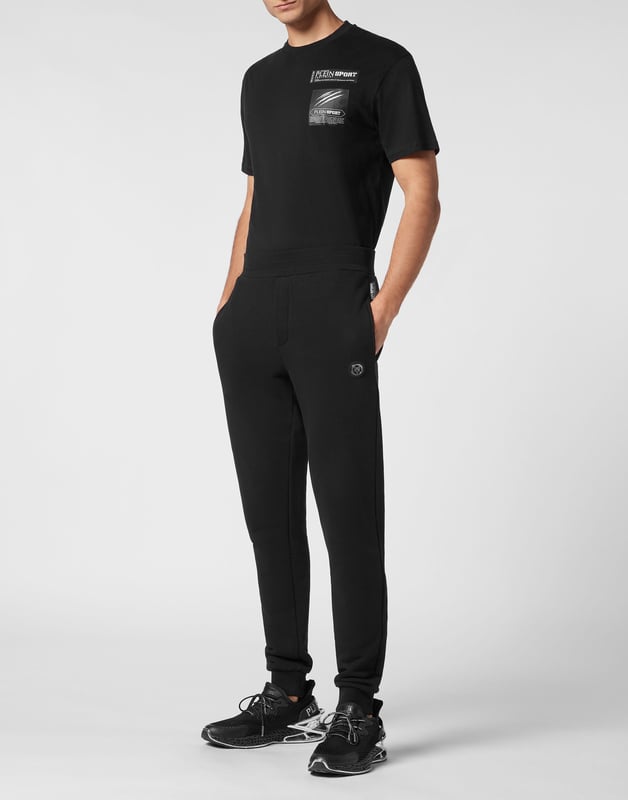 These joggers are the perfect match to achieve your goals. Comfort and performance add up to the style of Plein Sport.   Cotton fleece   Rubberized Tiger patch sewn on the left leg   Patches with lettering sewn on the back of left leg   Elasticated waistband    Two slit pockets   Loose fit for greater comfort   Rib knit bottom cuffs