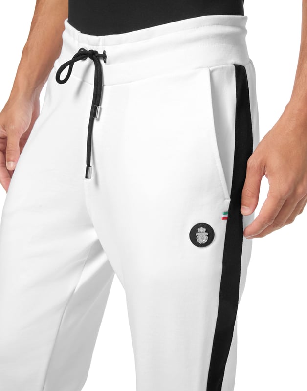 Eleva tu colección de ropa de estar por casa con estos lujosos pantalones de chándal, diseñados para ofrecer una comodidad refinada y un estilo contemporáneo. Confeccionados en algodón de primera calidad, aportan un toque sofisticado al estilo casual.    Confección en lujoso algodón que garantiza un tacto suave y transpirable.   Silueta entallada para un ajuste moderno y elegante.   Cintura elástica con cordón para una comodidad personalizada.   Los puños acanalados añaden un toque refinado a la silueta atlética.   Perfectos para combinar con una sudadera con capucha a juego o una camiseta informal.
