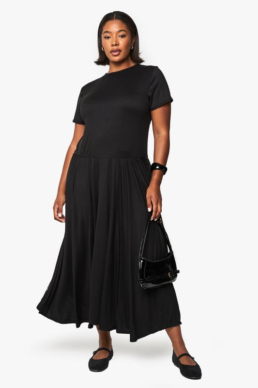 Relaxed T-shirt style bodice with classic crew neckline for everyday comfort
        Flowing maxi-length skirt with generous volume for graceful movement
        Short sleeves with neat finish for a clean, contemporary silhouette
        Soft viscose fabric drapes beautifully around the figure
        Versatile drop-waist design creates an effortlessly chic look
    
    This T-shirt-style maxi dress combines comfort with understated sophistication. The relaxed bodice transitions into a voluminous skirt that creates a flattering silhouette for all body types. Style with flat ballet pumps and a structured handbag as shown for daytime outings, or transform your look with chunky trainers and a denim jacket for casual weekend brunches. For evening gatherings, add statement jewellery and a leather jacket for an edgy contrast to the dress's flowing lines. The simple design makes this piece perfect for layering during cooler months - try with a longline cardigan and ankle boots. This wardrobe essential works beautifully for family gatherings, casual office days, or weekend city breaks where versatility is key.
