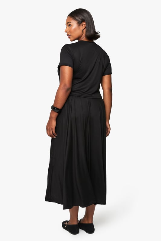 Relaxed T-shirt style bodice with classic crew neckline for everyday comfort
        Flowing maxi-length skirt with generous volume for graceful movement
        Short sleeves with neat finish for a clean, contemporary silhouette
        Soft viscose fabric drapes beautifully around the figure
        Versatile drop-waist design creates an effortlessly chic look
    
    This T-shirt-style maxi dress combines comfort with understated sophistication. The relaxed bodice transitions into a voluminous skirt that creates a flattering silhouette for all body types. Style with flat ballet pumps and a structured handbag as shown for daytime outings, or transform your look with chunky trainers and a denim jacket for casual weekend brunches. For evening gatherings, add statement jewellery and a leather jacket for an edgy contrast to the dress's flowing lines. The simple design makes this piece perfect for layering during cooler months - try with a longline cardigan and ankle boots. This wardrobe essential works beautifully for family gatherings, casual office days, or weekend city breaks where versatility is key.