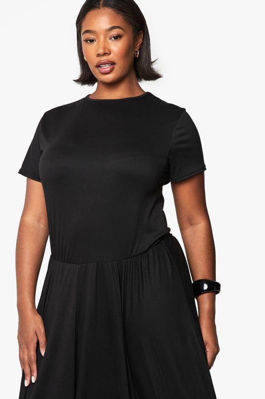 Relaxed T-shirt style bodice with classic crew neckline for everyday comfort
        Flowing maxi-length skirt with generous volume for graceful movement
        Short sleeves with neat finish for a clean, contemporary silhouette
        Soft viscose fabric drapes beautifully around the figure
        Versatile drop-waist design creates an effortlessly chic look
    
    This T-shirt-style maxi dress combines comfort with understated sophistication. The relaxed bodice transitions into a voluminous skirt that creates a flattering silhouette for all body types. Style with flat ballet pumps and a structured handbag as shown for daytime outings, or transform your look with chunky trainers and a denim jacket for casual weekend brunches. For evening gatherings, add statement jewellery and a leather jacket for an edgy contrast to the dress's flowing lines. The simple design makes this piece perfect for layering during cooler months - try with a longline cardigan and ankle boots. This wardrobe essential works beautifully for family gatherings, casual office days, or weekend city breaks where versatility is key.