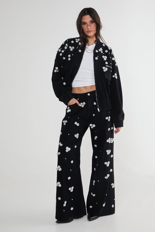 Stunning floral appliqu embellishments
        Oversized, relaxed fit for effortless style
        Front patch pockets for practicality
        Elasticated hem for a snug fit
        Versatile zip-up front closure
    
    Make a bold statement with this eye-catching embellished denim jacket from NastyGal. The scattered floral appliqus create a whimsical, feminine touch that contrasts beautifully with the rugged denim fabric. Perfect for those nights out when you want to turn heads, this jacket can be styled in numerous ways. Pair it with wide-leg jeans and a crop top for a trendy double denim look, or throw it over a slinky dress to add an edgy twist to your evening ensemble. The oversized fit allows for layering, making it ideal for transitional weather. Whether you're heading to a club, meeting friends at a bar, or exploring the urban nightlife, this unique piece will ensure you stand out from the crowd while keeping you comfortably stylish all night long.