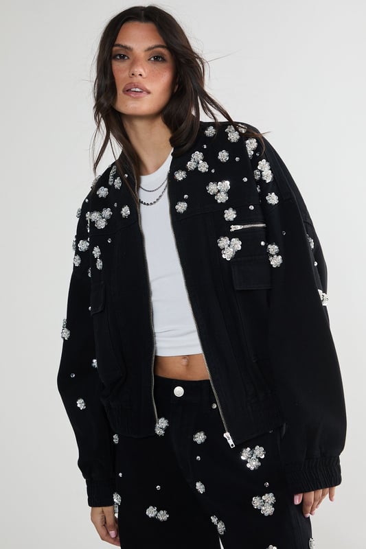 Stunning floral appliqu embellishments
        Oversized, relaxed fit for effortless style
        Front patch pockets for practicality
        Elasticated hem for a snug fit
        Versatile zip-up front closure
    
    Make a bold statement with this eye-catching embellished denim jacket from NastyGal. The scattered floral appliqus create a whimsical, feminine touch that contrasts beautifully with the rugged denim fabric. Perfect for those nights out when you want to turn heads, this jacket can be styled in numerous ways. Pair it with wide-leg jeans and a crop top for a trendy double denim look, or throw it over a slinky dress to add an edgy twist to your evening ensemble. The oversized fit allows for layering, making it ideal for transitional weather. Whether you're heading to a club, meeting friends at a bar, or exploring the urban nightlife, this unique piece will ensure you stand out from the crowd while keeping you comfortably stylish all night long.