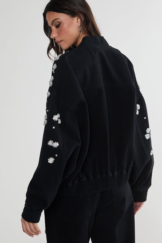 Stunning floral appliqu embellishments
        Oversized, relaxed fit for effortless style
        Front patch pockets for practicality
        Elasticated hem for a snug fit
        Versatile zip-up front closure
    
    Make a bold statement with this eye-catching embellished denim jacket from NastyGal. The scattered floral appliqus create a whimsical, feminine touch that contrasts beautifully with the rugged denim fabric. Perfect for those nights out when you want to turn heads, this jacket can be styled in numerous ways. Pair it with wide-leg jeans and a crop top for a trendy double denim look, or throw it over a slinky dress to add an edgy twist to your evening ensemble. The oversized fit allows for layering, making it ideal for transitional weather. Whether you're heading to a club, meeting friends at a bar, or exploring the urban nightlife, this unique piece will ensure you stand out from the crowd while keeping you comfortably stylish all night long.