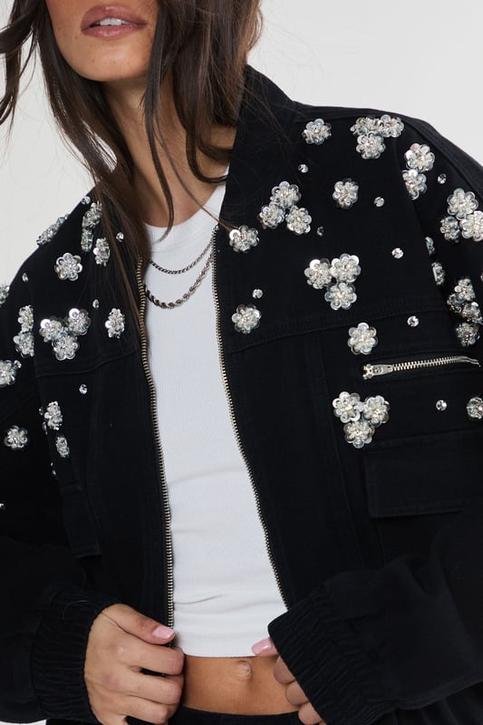 Stunning floral appliqu embellishments
        Oversized, relaxed fit for effortless style
        Front patch pockets for practicality
        Elasticated hem for a snug fit
        Versatile zip-up front closure
    
    Make a bold statement with this eye-catching embellished denim jacket from NastyGal. The scattered floral appliqus create a whimsical, feminine touch that contrasts beautifully with the rugged denim fabric. Perfect for those nights out when you want to turn heads, this jacket can be styled in numerous ways. Pair it with wide-leg jeans and a crop top for a trendy double denim look, or throw it over a slinky dress to add an edgy twist to your evening ensemble. The oversized fit allows for layering, making it ideal for transitional weather. Whether you're heading to a club, meeting friends at a bar, or exploring the urban nightlife, this unique piece will ensure you stand out from the crowd while keeping you comfortably stylish all night long.