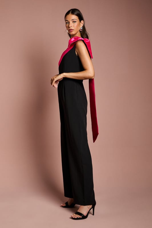 Bow One Shoulder Jumpsuit One-shoulder design with a dramatic bow detail
Wide-leg jumpsuit silhouette with a flattering waist tie
crepe fabric with a luxurious drape
Sleeveless bodice with a fitted waist
Full-length wide legs for an elegant, flowing look
Exuding sophistication and glamour, this jumpsuit is a showstopping choice for formal occasions. The one-shoulder neckline with a striking bow detail adds a touch of drama, while the crepe fabric drapes beautifully for a refined look. Style it with statement jewellery and heels for a wedding or evening event, or pair it with a fascinator and clutch for a day at the races. With its flattering waist tie and flowing wide legs, this jumpsuit is sure to turn heads and make a lasting impression.