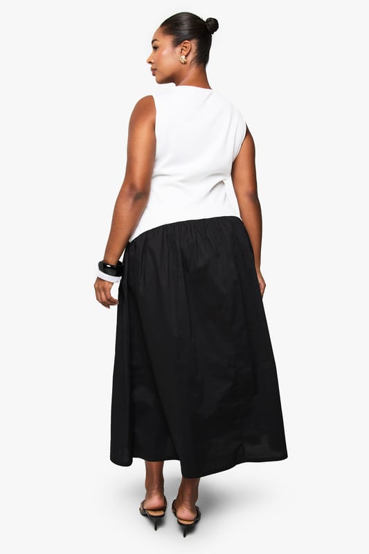 Striking contrast design with fitted sleeveless bodice and flowing midi skirt
        Elegant boat neckline offering a sophisticated silhouette
        Comfortable cotton fabric providing breathable wear throughout the day
        Versatile midi length perfect for various seasonal styling options
        Inclusive plus sizing designed to flatter and celebrate your curves
    
    This chic contrast midikleid combines contemporary style with effortless comfort. The structured white bodice creates a flattering foundation, whilst the flowing black skirt adds movement and drama to your silhouette. Style with minimalist flip flops and statement sunglasses for daytime casual events, or transform your look with block heels and bold accessories for family gatherings. The versatile design works brilliantly with a denim jacket for cooler evenings or a lightweight cardigan for spring outings. Add a structured handbag and chunky bracelet to complete the ensemble with modern flair. This Boohoo piece embodies the brand's commitment to inclusive fashion that doesn't compromise on trend-forward design - a wardrobe essential that transitions seamlessly from casual brunches to afternoon garden parties.