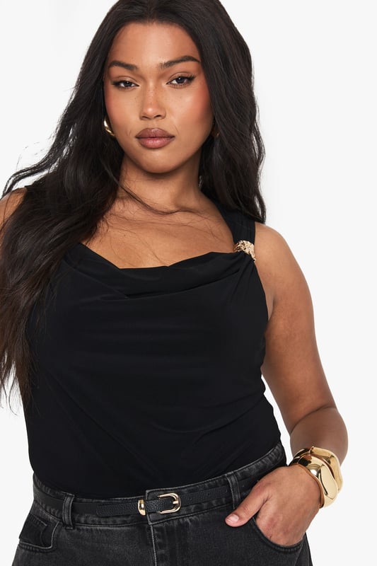 PLUS GOLD TRIM COWL FRONT BODYSUIT Elegant cowl neckline that drapes beautifully across the dcolletage
Striking gold-tone hardware detail on one shoulder strap for added glamour
Figure-flattering body design that contours your silhouette
Versatile sleeveless style perfect for layering or wearing alone
Designed specifically for plus sizes with a comfortable, confidence-boosting fit
Make a statement after dark with this sophisticated body featuring an alluring cowl neckline and eye-catching gold hardware detail. The sleek design hugs your curves in all the right places whilst the draped front adds a touch of drama to your evening ensemble. Style with wide-leg denim and strappy heels as seen on our model for an effortlessly chic night-out look, or dress it up with a leather midi skirt and blazer for cocktail hour. The versatile piece transitions seamlessly from drinks with the girls to dancing until dawn. Complete your look with statement gold jewellery to complement the luxe hardware detail - this body is destined to become your new going-out favourite.