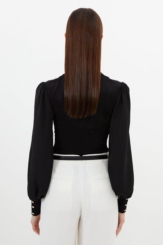 Jersey Ponte And Georgette Mix Tie Neck Long Sleeve Bodysuit This Karen Millen bodysuit combines classic elegance with contemporary styling. The contrasting textures of jersey and georgette create visual interest, while the statement pussy bow adds a touch of feminine charm. The balloon sleeves provide dramatic volume balanced by the fitted bodice, creating a flattering silhouette. Perfect for family gatherings or casual work events, this bodysuit can be dressed down with tailored denim and flats for weekend brunches, or paired with a pencil skirt for more refined occasions. The secure bodysuit design eliminates the need for constant re-tucking, ensuring you maintain a sleek appearance throughout the day. A versatile wardrobe staple that offers both comfort and sophistication. Jersey bodysuit featuring a georgette pussy bow detail Voluminous balloon sleeves with fitted cuffs and button detailing Round neckline Smooth, form-fitting designe