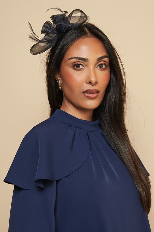 Delicate mesh floral design with intricate detailing
        Elegant feather embellishment for a touch of sophistication
        Comfortable headband structure for secure all-day wear
        Lightweight construction perfect for formal occasions
        Versatile placement options - wear centred or to one side
    
    Make a striking impression at your next special event with this exquisitely crafted mesh bow and feather headband from Wallis. The dimensional floral design creates a beautiful focal point that draws the eye, whilst the delicate feather detail adds movement and grace. Style with an elegant updo to showcase the headband's intricate detailing, or wear with flowing locks for a more relaxed yet sophisticated look. Perfect for weddings, race days and formal gatherings, this versatile accessory pairs beautifully with both high-neck dresses and open necklines. The secure fit ensures comfort throughout your event, allowing you to dance and socialise with confidence. Complete your ensemble with complementary jewellery for a coordinated, glamorous finish that reflects the Wallis woman's sophisticated aesthetic.