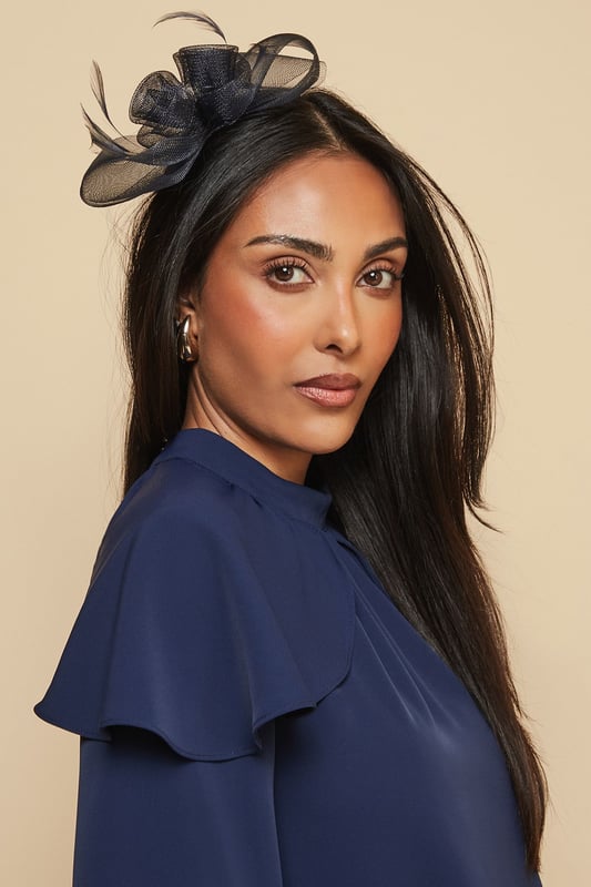 Delicate mesh floral design with intricate detailing
        Elegant feather embellishment for a touch of sophistication
        Comfortable headband structure for secure all-day wear
        Lightweight construction perfect for formal occasions
        Versatile placement options - wear centred or to one side
    
    Make a striking impression at your next special event with this exquisitely crafted mesh bow and feather headband from Wallis. The dimensional floral design creates a beautiful focal point that draws the eye, whilst the delicate feather detail adds movement and grace. Style with an elegant updo to showcase the headband's intricate detailing, or wear with flowing locks for a more relaxed yet sophisticated look. Perfect for weddings, race days and formal gatherings, this versatile accessory pairs beautifully with both high-neck dresses and open necklines. The secure fit ensures comfort throughout your event, allowing you to dance and socialise with confidence. Complete your ensemble with complementary jewellery for a coordinated, glamorous finish that reflects the Wallis woman's sophisticated aesthetic.