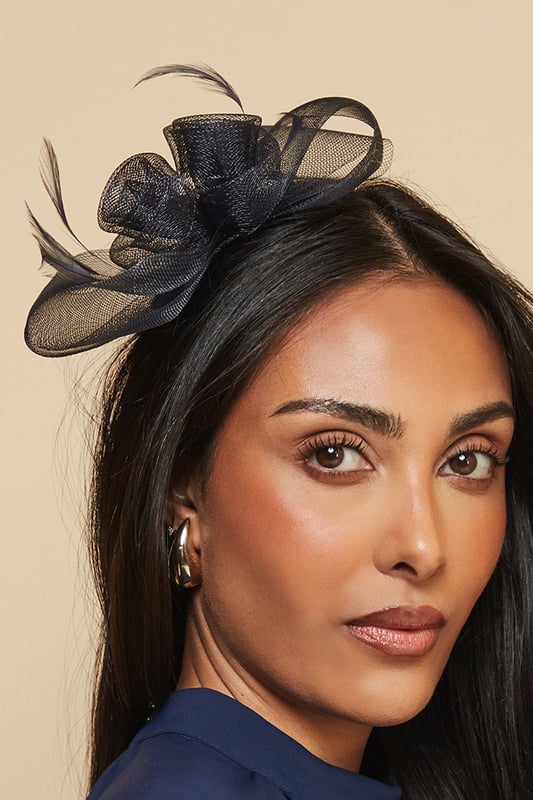 Delicate mesh floral design with intricate detailing
        Elegant feather embellishment for a touch of sophistication
        Comfortable headband structure for secure all-day wear
        Lightweight construction perfect for formal occasions
        Versatile placement options - wear centred or to one side
    
    Make a striking impression at your next special event with this exquisitely crafted mesh bow and feather headband from Wallis. The dimensional floral design creates a beautiful focal point that draws the eye, whilst the delicate feather detail adds movement and grace. Style with an elegant updo to showcase the headband's intricate detailing, or wear with flowing locks for a more relaxed yet sophisticated look. Perfect for weddings, race days and formal gatherings, this versatile accessory pairs beautifully with both high-neck dresses and open necklines. The secure fit ensures comfort throughout your event, allowing you to dance and socialise with confidence. Complete your ensemble with complementary jewellery for a coordinated, glamorous finish that reflects the Wallis woman's sophisticated aesthetic.