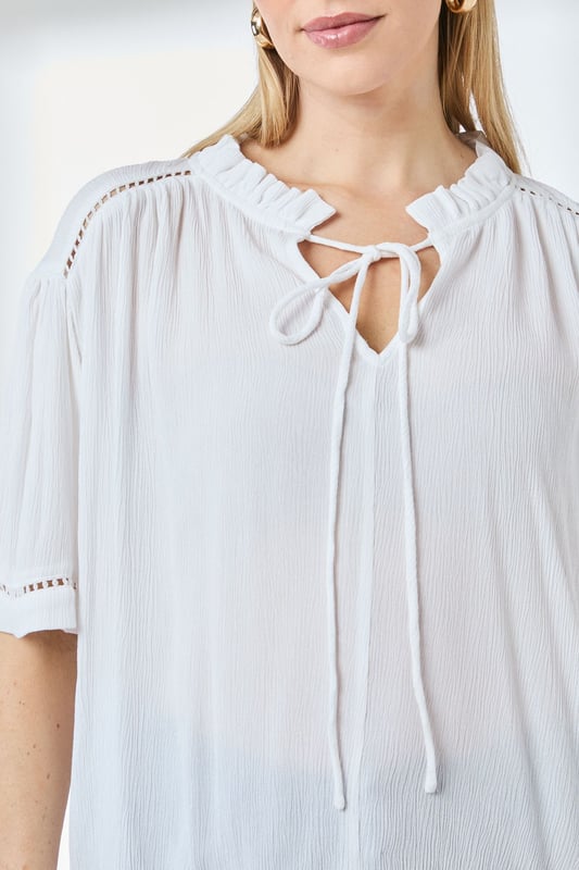 Distinctive ladder trim detailing along the neckline creates visual interest
        Relaxed regular fit with gathered shoulder design for effortless movement
        Elegant tie-front closure adds a feminine touch to this versatile blouse
        Short puff sleeves with trim detail offer a contemporary silhouette
        Textured woven fabric with gentle gathering at the back for added dimension
    
    This charming Principles blouse combines casual comfort with thoughtful design elements. The ladder trim detailing and tie-front feature create a relaxed yet put-together look that transitions seamlessly from day to evening. Style with white trousers and flat sandals as shown for a polished weekend ensemble, or pair with your favourite denim and trainers for casual coffee dates. The lightweight viscose fabric drapes beautifully, making it ideal for warmer days or layering under a cardigan when temperatures drop. Perfect for family gatherings, casual brunches or weekend shopping trips, this blouse offers the versatility to be dressed up with tailored trousers or kept casual with a denim skirt. The subtle textural elements and considered details reflect Principles' commitment to creating wardrobe staples with distinctive character.